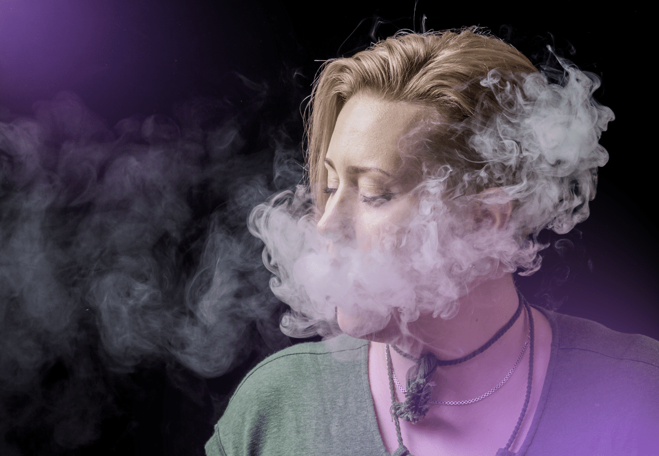 Woman with exhaling white smoke after using a pipe